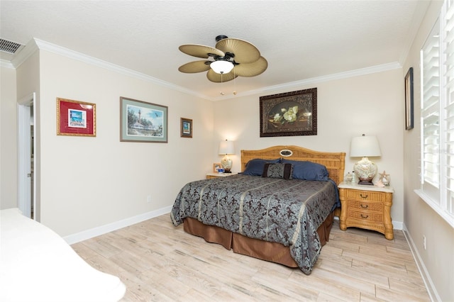 bedroom featuring baseboards, light wood-style floors, visible vents, and ornamental molding