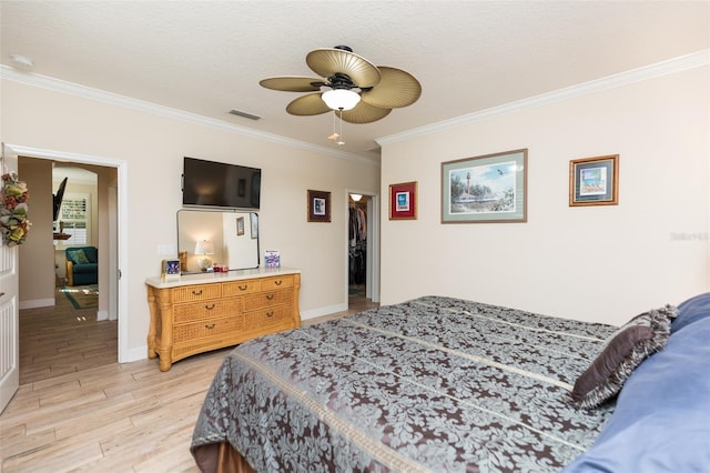 bedroom featuring visible vents, crown molding, ceiling fan, baseboards, and light wood-style floors