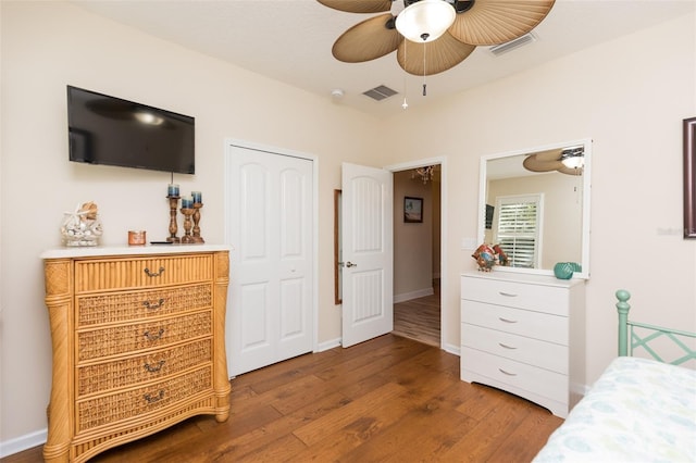 bedroom with a ceiling fan, dark wood-style floors, visible vents, and baseboards