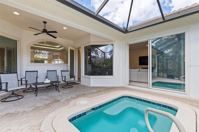 view of swimming pool featuring a ceiling fan, glass enclosure, and a patio area