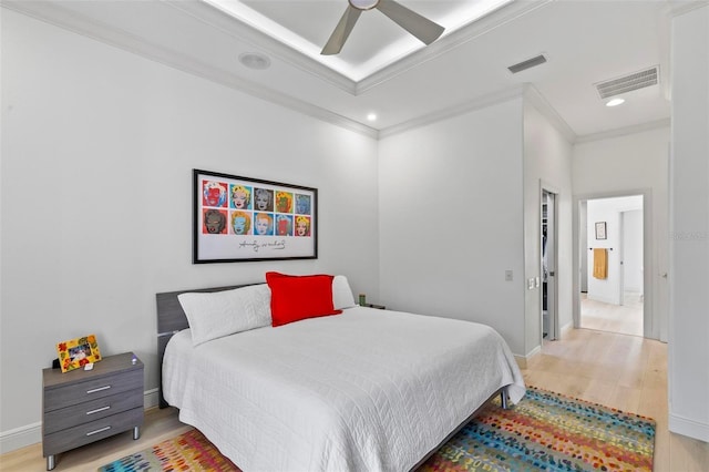 bedroom with visible vents, crown molding, and wood finished floors