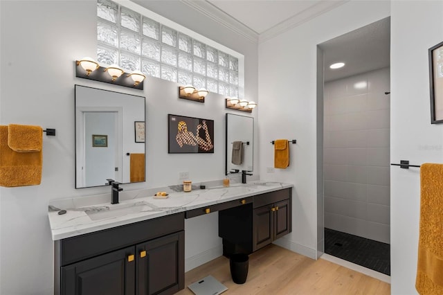 bathroom with double vanity, ornamental molding, a sink, wood finished floors, and walk in shower