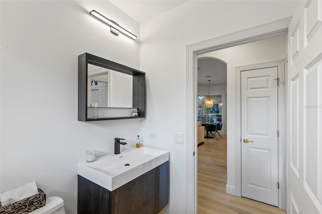 bathroom with vanity, toilet, and wood finished floors