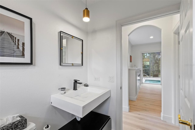 bathroom featuring a sink, wood finished floors, and baseboards