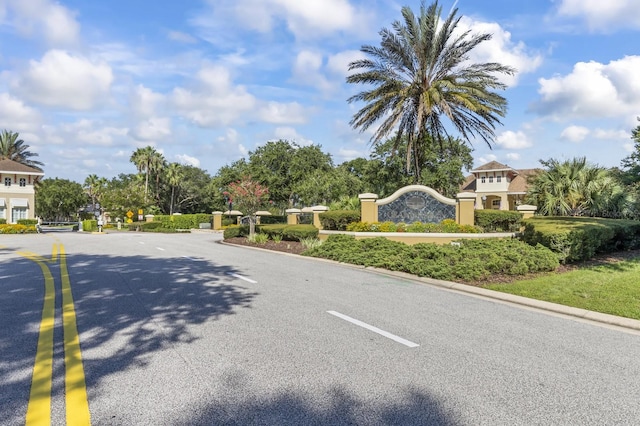 view of street featuring a gated entry and curbs