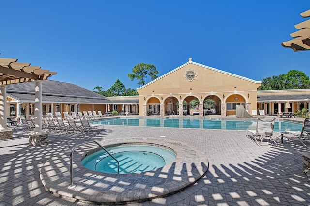 pool with a patio, a pergola, and a hot tub