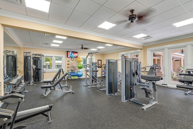 gym with visible vents, ornamental molding, a ceiling fan, a drop ceiling, and baseboards