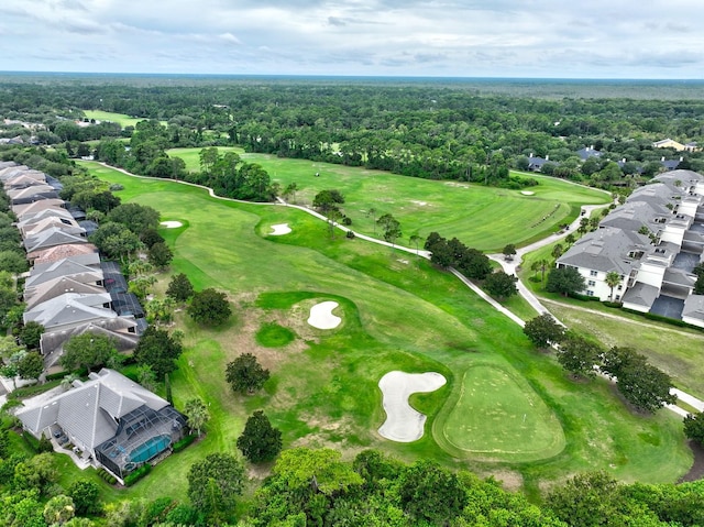 aerial view with view of golf course and a wooded view