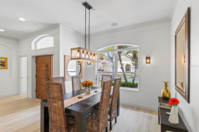dining room with recessed lighting, baseboards, crown molding, and light wood-style floors