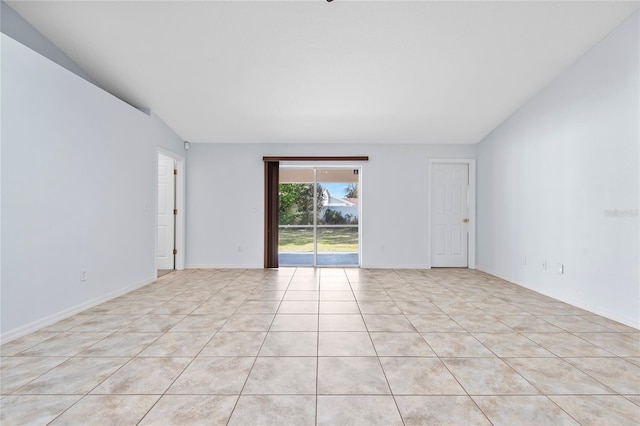 empty room with vaulted ceiling and baseboards