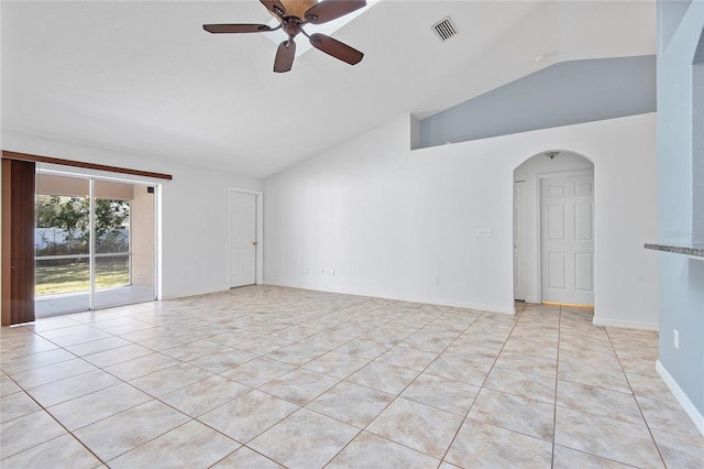 unfurnished room with lofted ceiling, ceiling fan, arched walkways, and light tile patterned floors