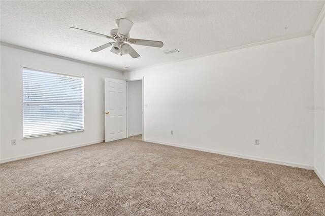 spare room with baseboards, light colored carpet, ceiling fan, a textured ceiling, and crown molding