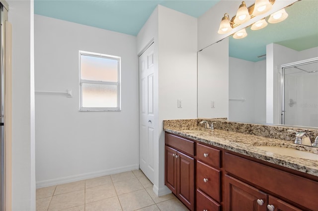 full bath with double vanity, tile patterned floors, a sink, and a shower stall