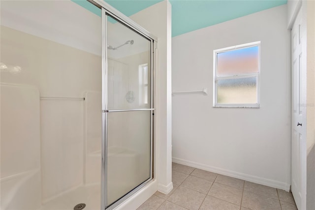 full bathroom with tile patterned flooring, a shower stall, and baseboards