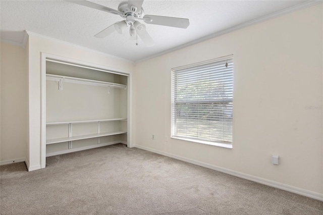 unfurnished bedroom featuring carpet floors, a closet, ornamental molding, a textured ceiling, and baseboards