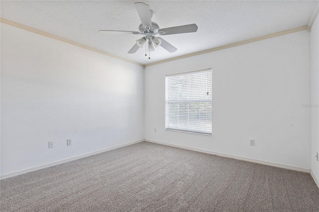 carpeted spare room with a textured ceiling, ceiling fan, ornamental molding, and baseboards