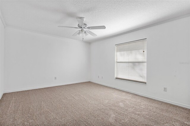 carpeted empty room featuring a textured ceiling, ceiling fan, and crown molding