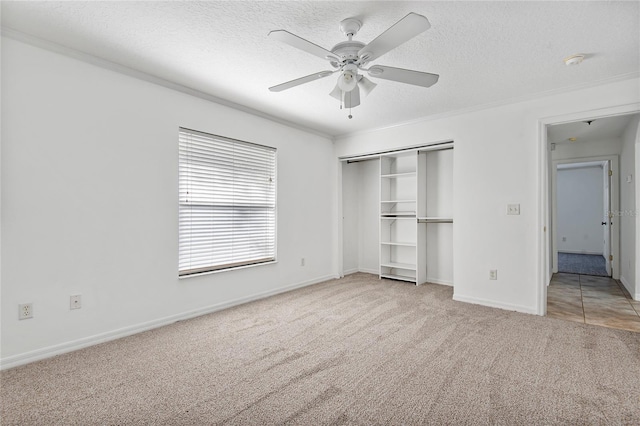 unfurnished bedroom with carpet, a closet, crown molding, and a textured ceiling