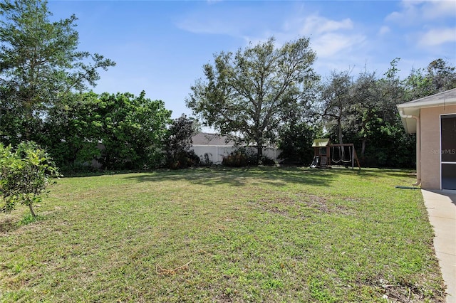 view of yard featuring a playground and fence