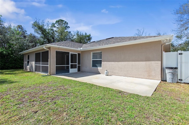 back of house featuring stucco siding, a lawn, a sunroom, a patio area, and fence