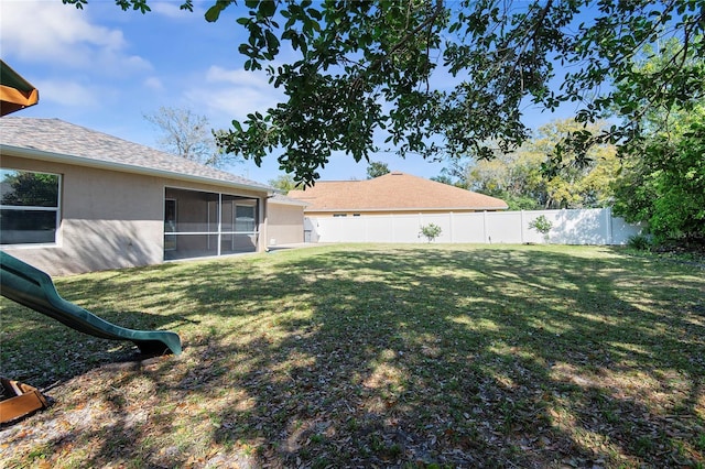 view of yard with a sunroom and a fenced backyard