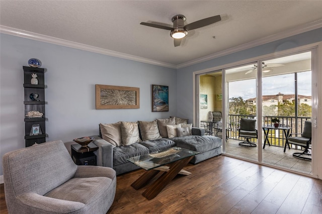 living room featuring a textured ceiling, ornamental molding, wood finished floors, and a ceiling fan