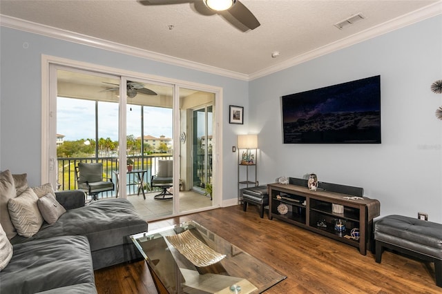 living room with visible vents, ornamental molding, ceiling fan, a textured ceiling, and wood finished floors