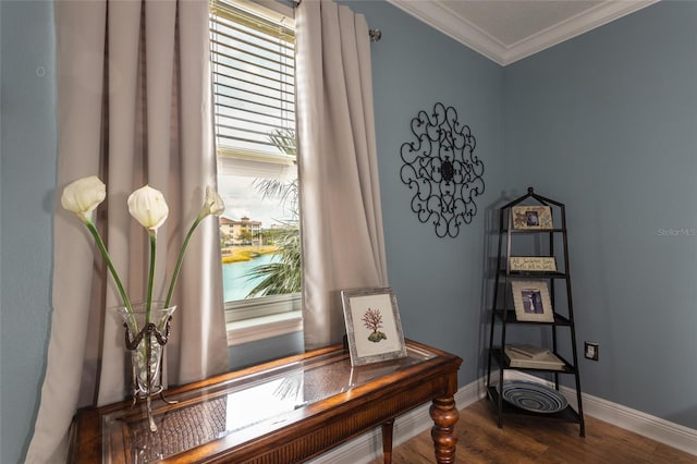 interior space with baseboards, ornamental molding, and wood finished floors