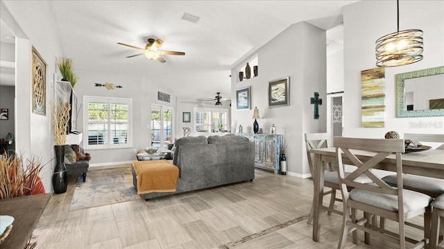 living room featuring baseboards, vaulted ceiling, visible vents, and a ceiling fan