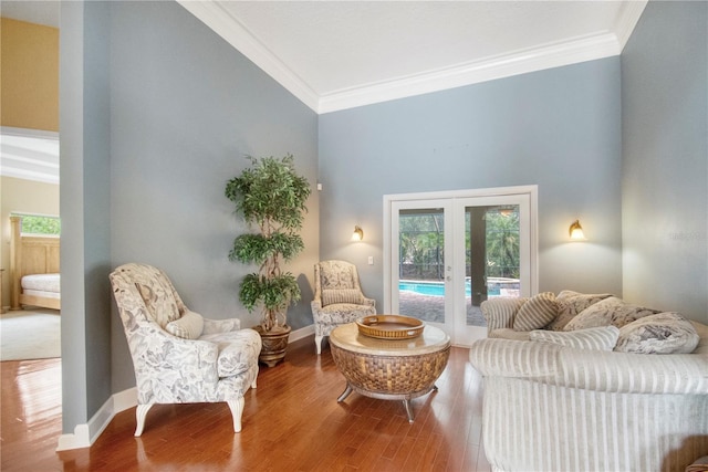 living area featuring wood finished floors, french doors, baseboards, and ornamental molding