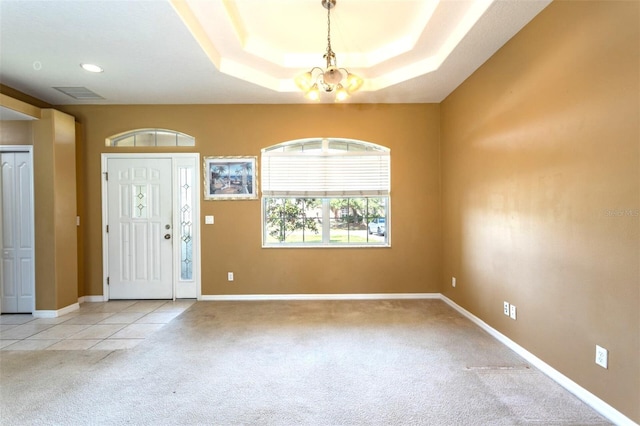 foyer featuring a chandelier, visible vents, baseboards, carpet, and a raised ceiling