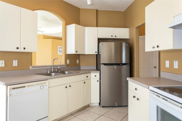 kitchen featuring white appliances, light tile patterned floors, light countertops, and a sink