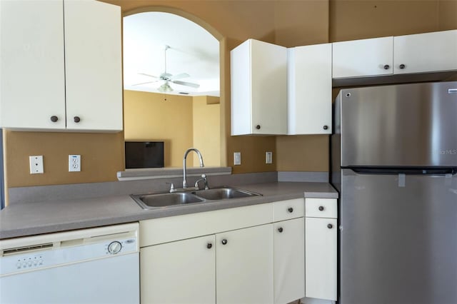 kitchen with freestanding refrigerator, white cabinetry, dishwasher, and a sink