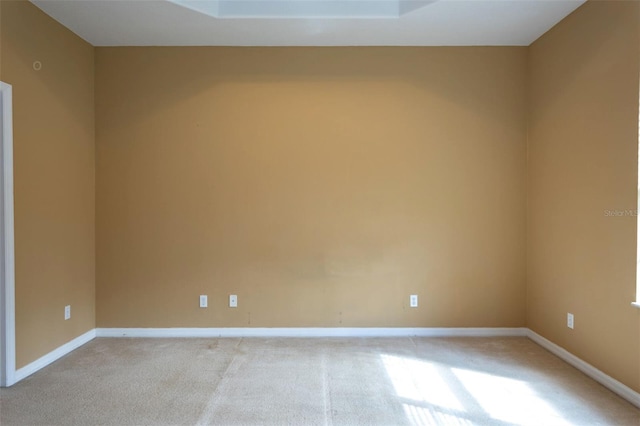 unfurnished room with light colored carpet and baseboards