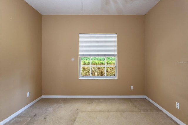 empty room with baseboards and light colored carpet