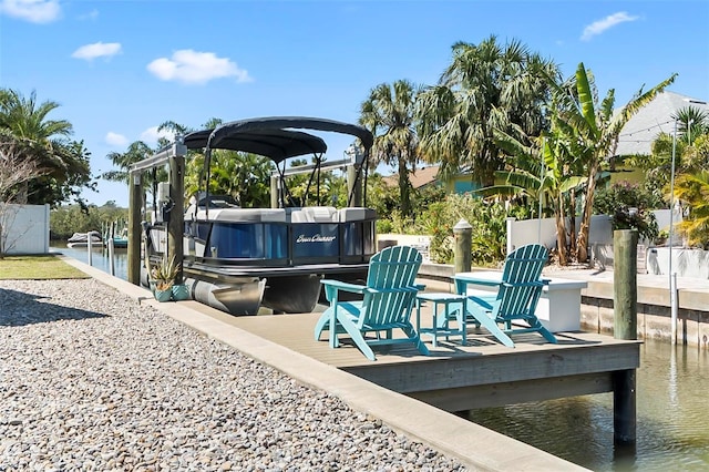 exterior space featuring boat lift, a water view, a boat dock, and fence