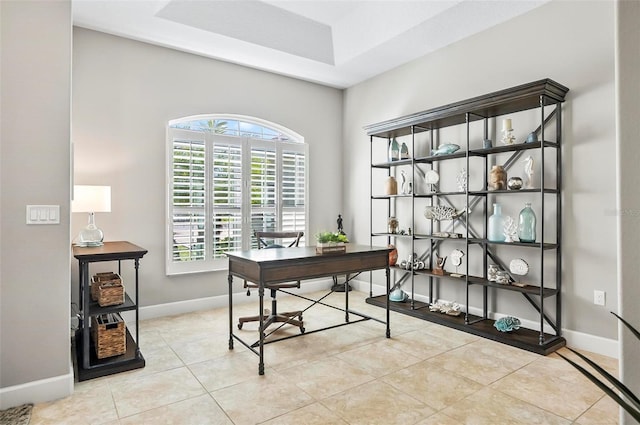 tiled office with a tray ceiling and baseboards