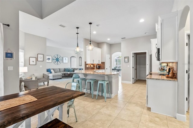 dining area with visible vents, recessed lighting, arched walkways, light tile patterned floors, and baseboards