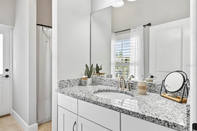 full bath with vanity and baseboards