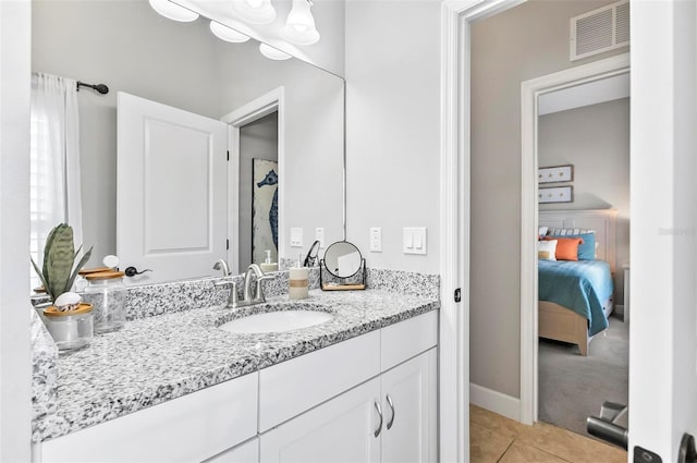 bathroom featuring vanity, tile patterned floors, baseboards, and visible vents