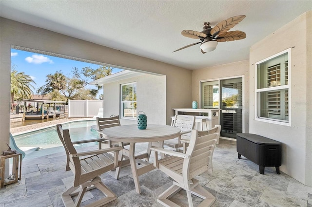 view of patio / terrace featuring outdoor dining space, fence, an outdoor pool, and ceiling fan