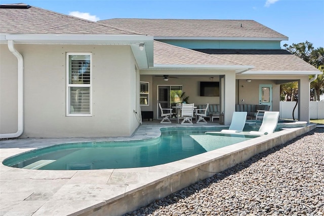 exterior space with an outdoor pool, a patio area, stucco siding, and a shingled roof