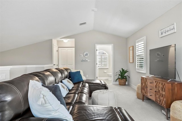 carpeted living area featuring visible vents, baseboards, and vaulted ceiling