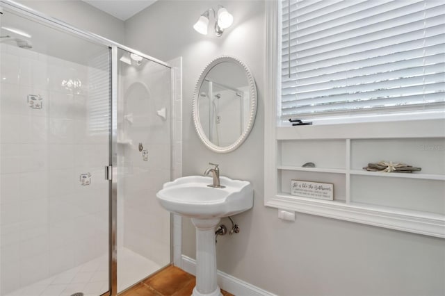 bathroom featuring baseboards and a stall shower