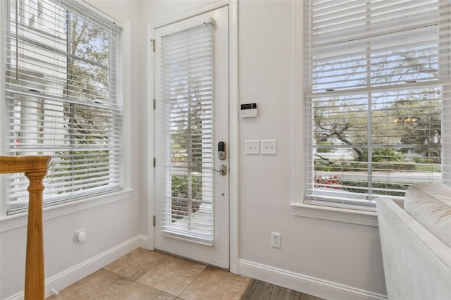 entryway featuring baseboards and light tile patterned flooring