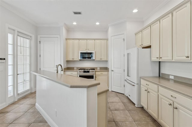 kitchen featuring white appliances, an island with sink, visible vents, and ornamental molding