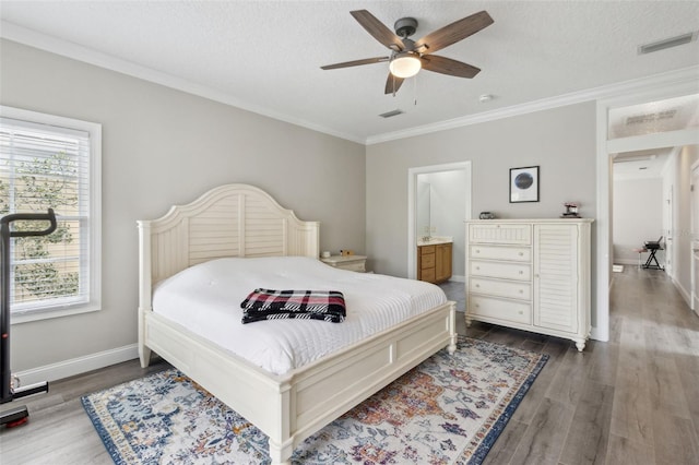 bedroom featuring visible vents, crown molding, and wood finished floors