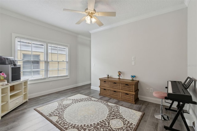 office space featuring ceiling fan, baseboards, ornamental molding, wood finished floors, and a textured ceiling