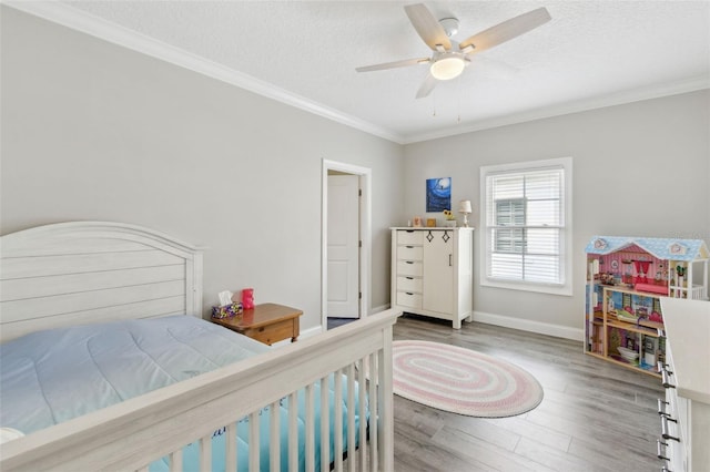 bedroom featuring ornamental molding, a textured ceiling, and wood finished floors