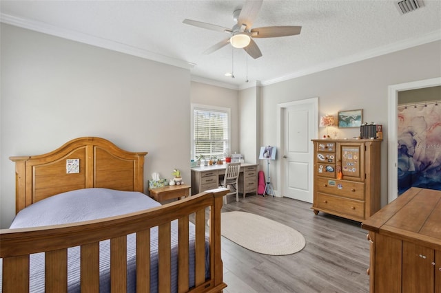 bedroom with visible vents, wood finished floors, and crown molding